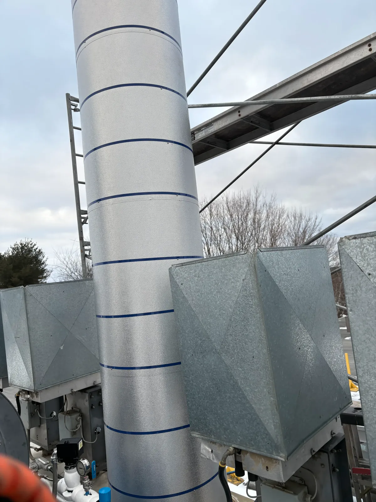 Tuyau vertical extérieur calorifugé sous un revêtement d'aluminium cerclé